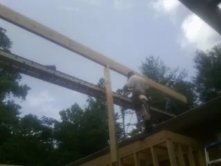 Carpenter setting a ridge beam over a new addition frame — Ice Dam Removal by Roofing Brothers in Mc Cormick