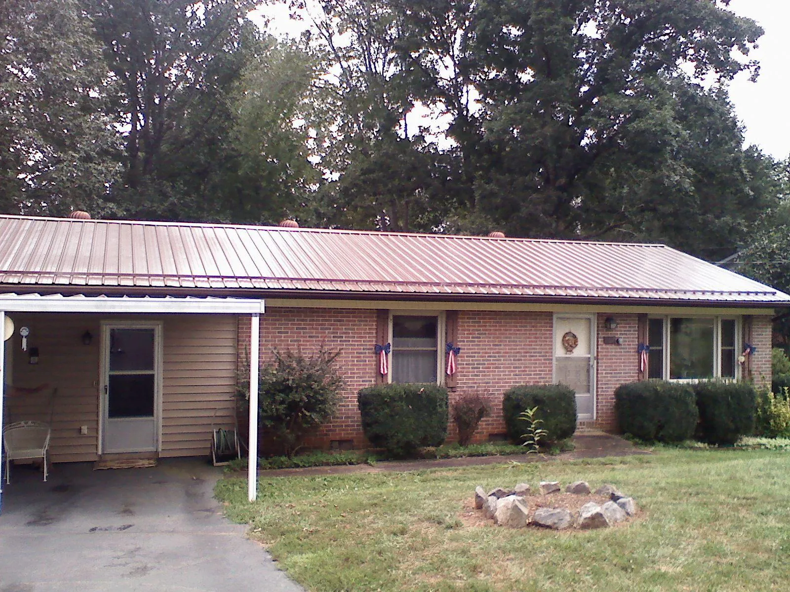 Bronze metal roof and carport on a brick ranch home — Roof Repair work by our crew in Mc Cormick
